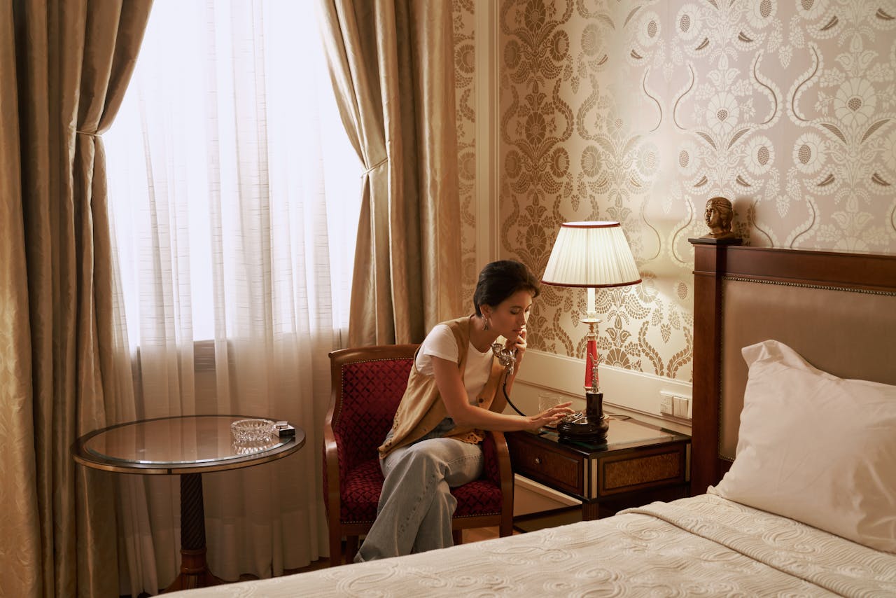 Mastering the First Impression: Your intriguing post title goes here A woman talks on a vintage phone in a luxurious hotel room, creating a retro ambiance.